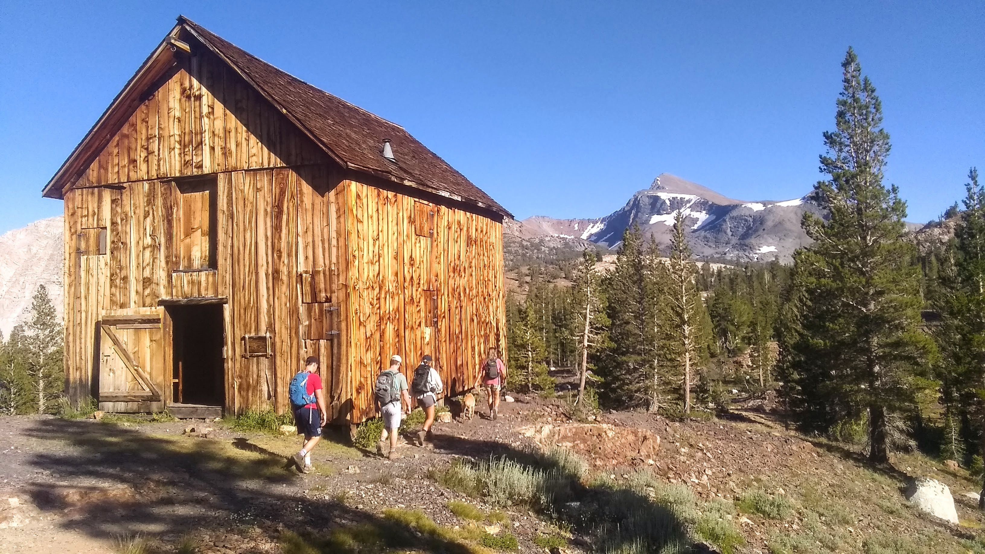 Een familie wandelt langs een houten hut in Yosemite National Park, Californië, VS