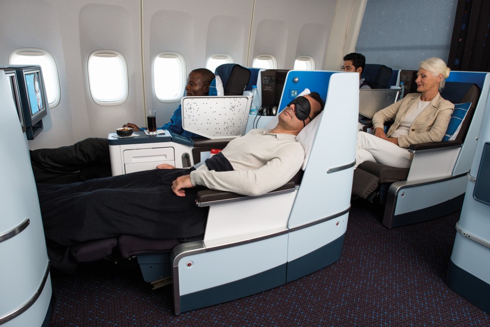 Passagiers ontspannen in een business class stoel op een internationale vlucht.