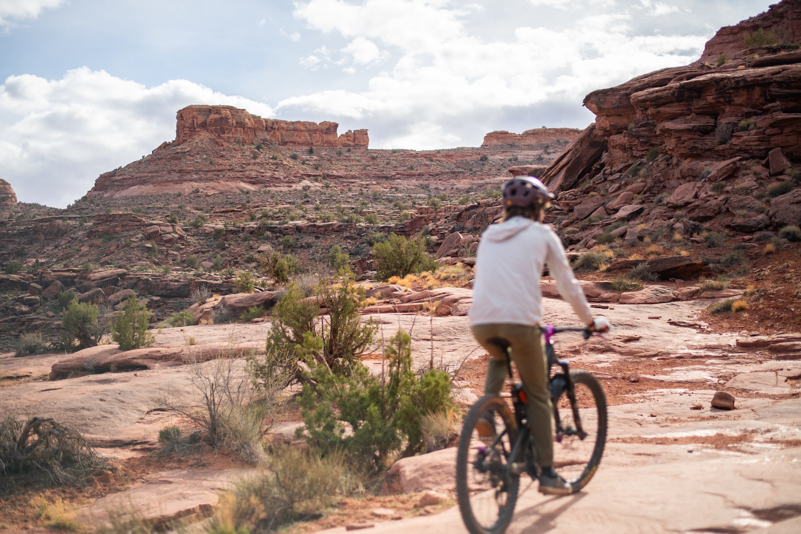 Een dame fietst door Grand County in Utah, VS, omringd door rode rotsformaties.