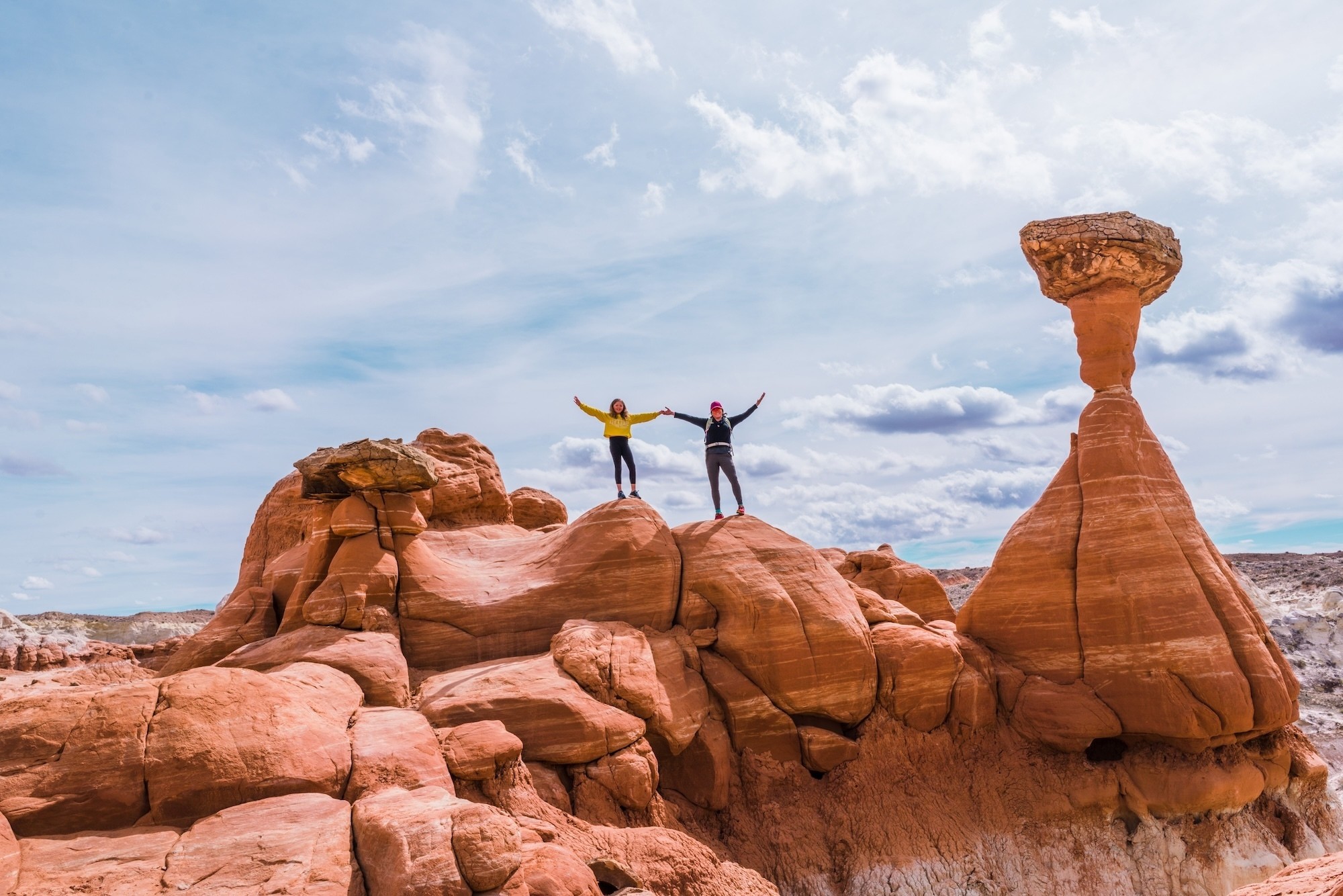 Twee mensen houden hun armen in de arm terwijl ze bovenop rotsen staan in Kanab, Utah