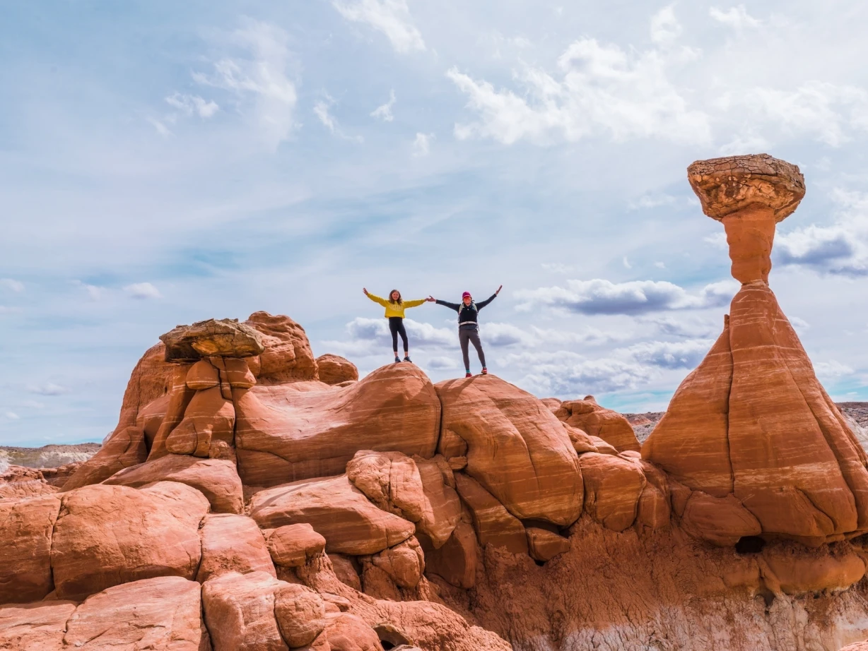 Twee mensen houden hun armen in de arm terwijl ze bovenop rotsen staan in Kanab, Utah