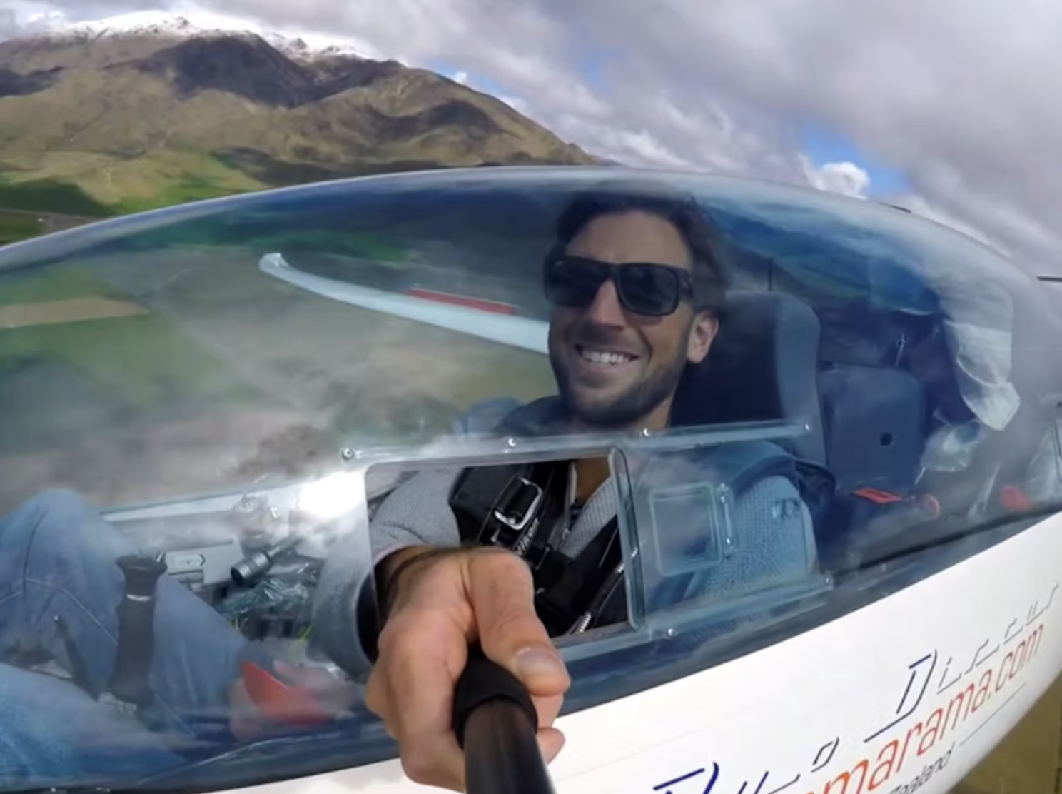 Michiel neemt een selfie met een selfie stick vanuit een klein vliegtuigje