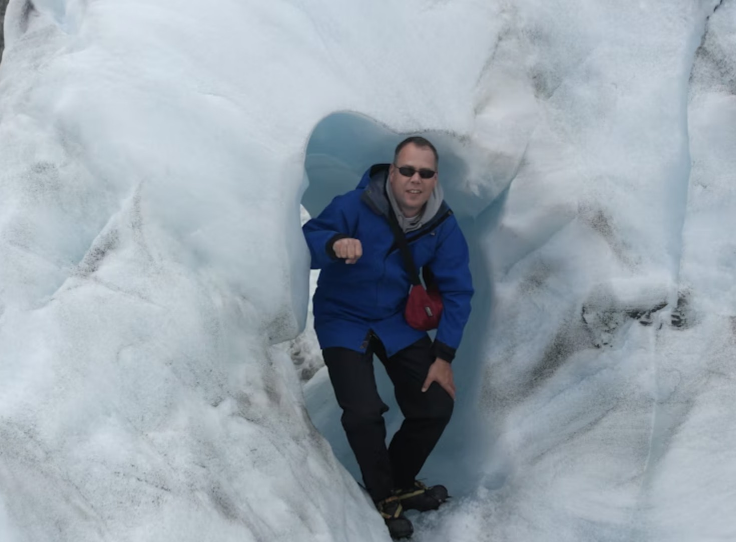 Mischa kijkt naar de camera omringd door ijsmuur