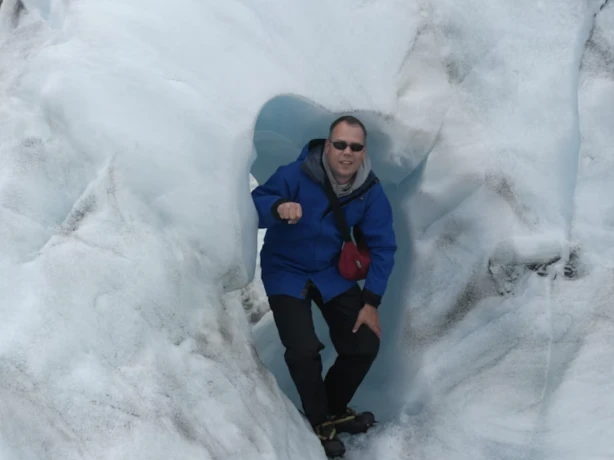 Mischa kijkt naar de camera omringd door ijsmuur