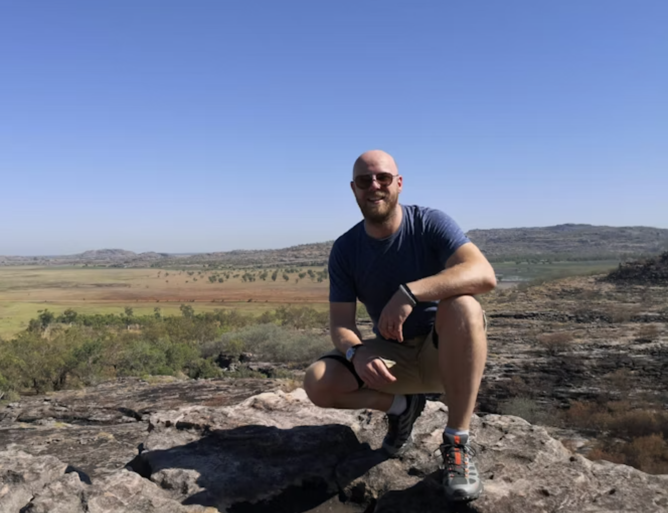 Bart glimlacht naar de camera met een uitzicht op de achtergrond
