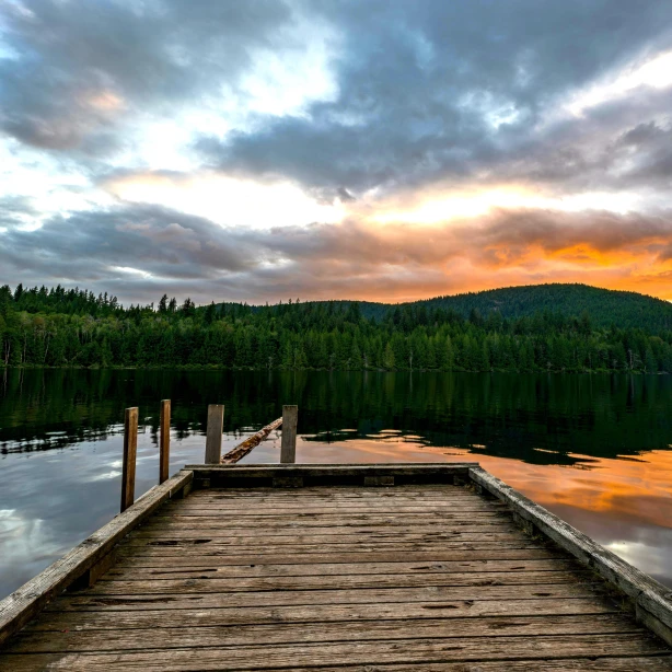 Een kleine houten steiger steekt uit in de Powell River aan de Sunshine Coast in Canada, terwijl de zon in de buurt ondergaat