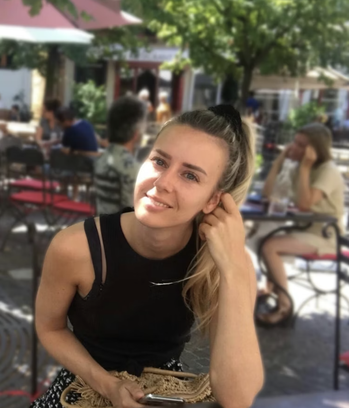 Gerbrich glimlacht naar de camera terwijl hij buiten in een restaurant zit te eten