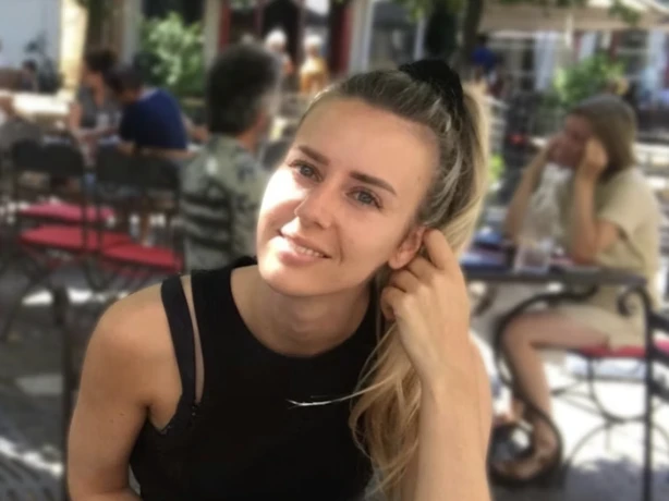 Gerbrich glimlacht naar de camera terwijl hij buiten in een restaurant zit te eten