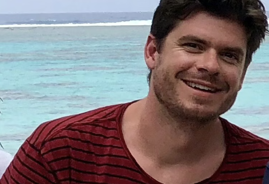 Hendrik-Jan lacht naar de camera met de oceaan op de achtergrond