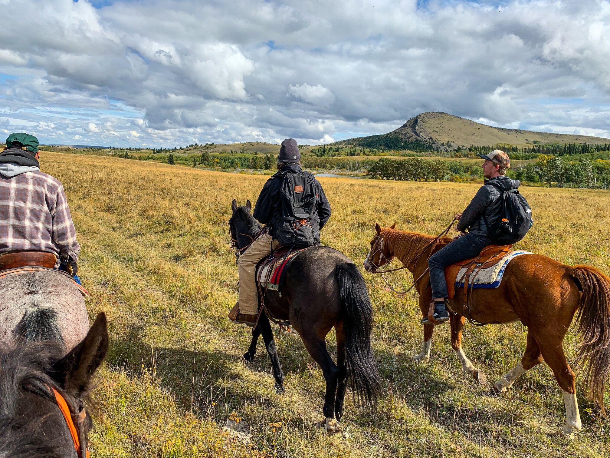 Leden van de Blackfeet-stam nemen een toerist mee op een paardrijavontuur door het landschap van Montana, VS.