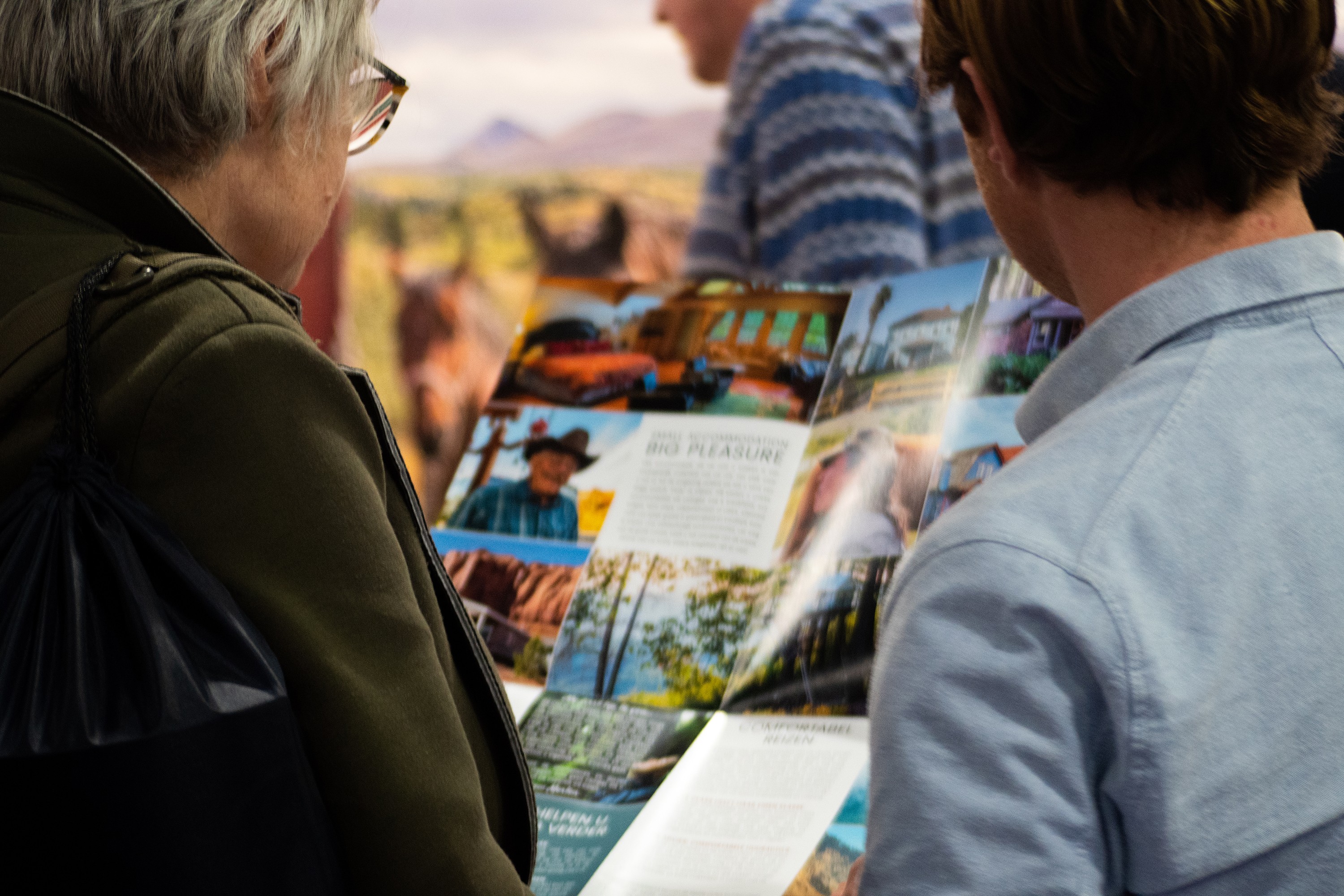 Twee mensen lezen een brochure van Little America om hun reis naar Noord-Amerika te plannen.