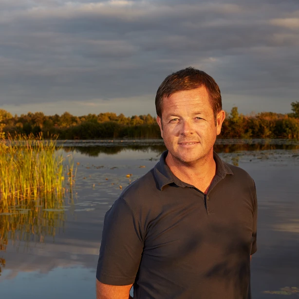 Andrew Morton glimlacht naar de camera