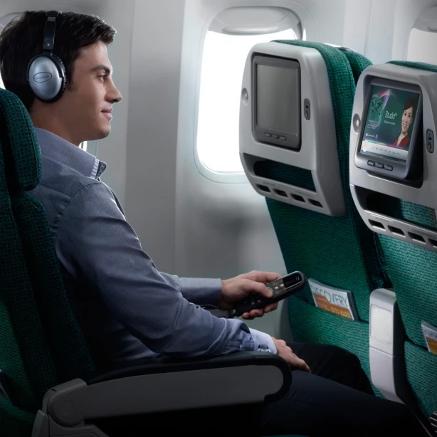 Een man geniet van het entertainment aan boord in Premium Economy op een vlucht van Cathay Pacific