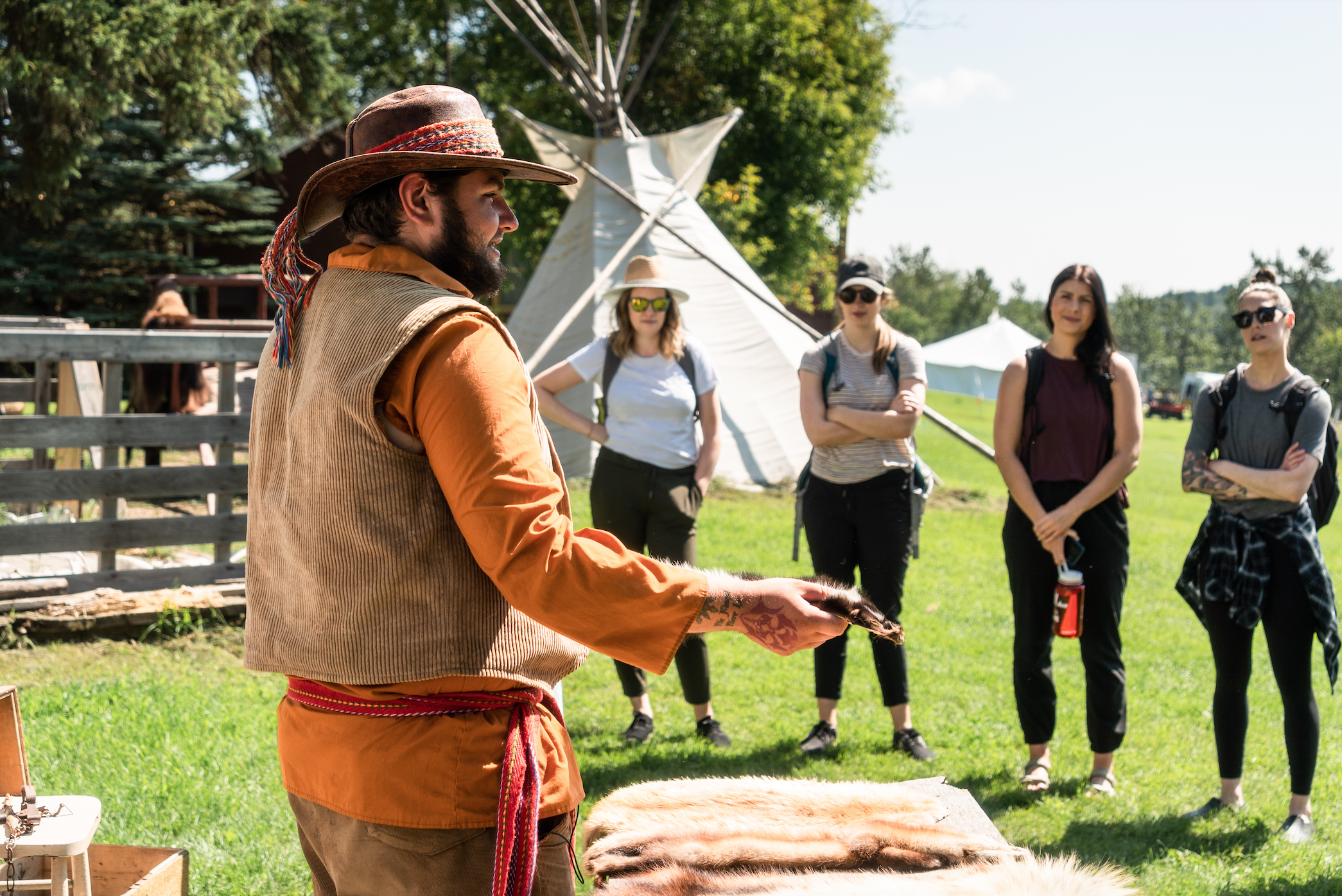 Een inheemse Metis-gids geeft uitleg aan een groep toeristen in Alberta, Canada.